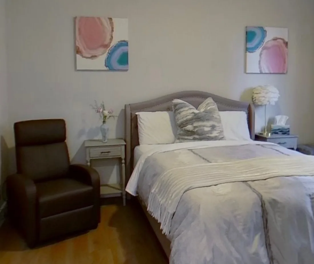 A serene bedroom with a recliner beside the bed